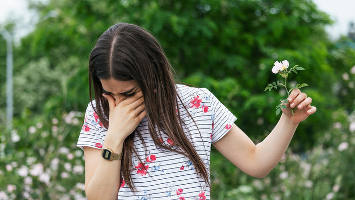 Balmonds Hayfever Hacks - woman holding a flower and sneezing