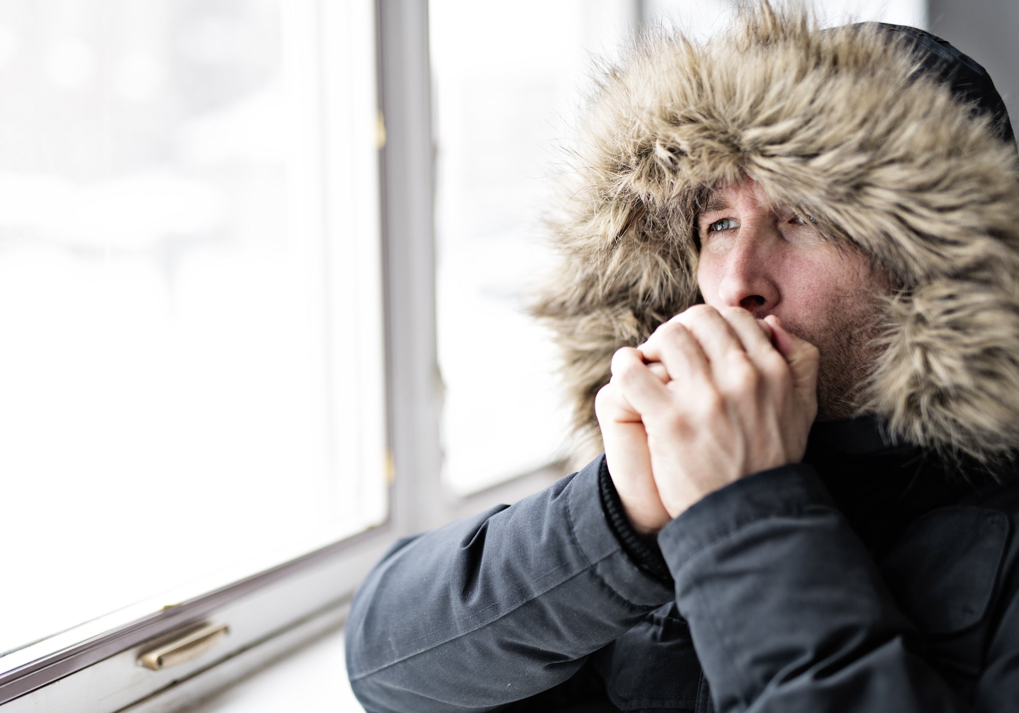 blowing warm air onto hands in cold weather