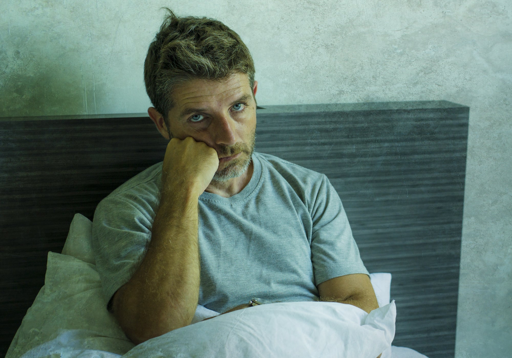 person feeling un well sitting in bed