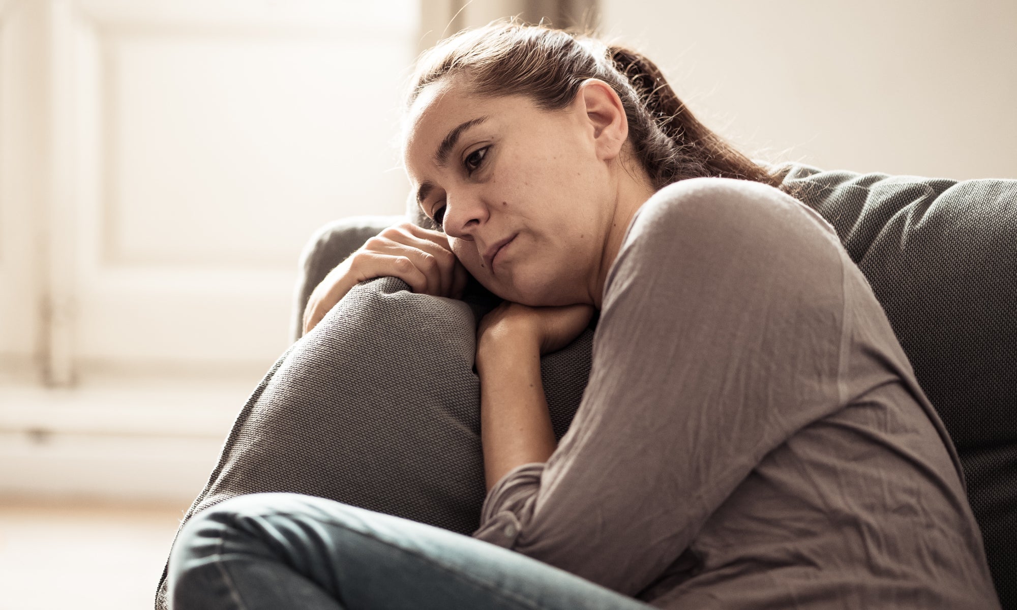 Person sitting on a sofa feeling unwell