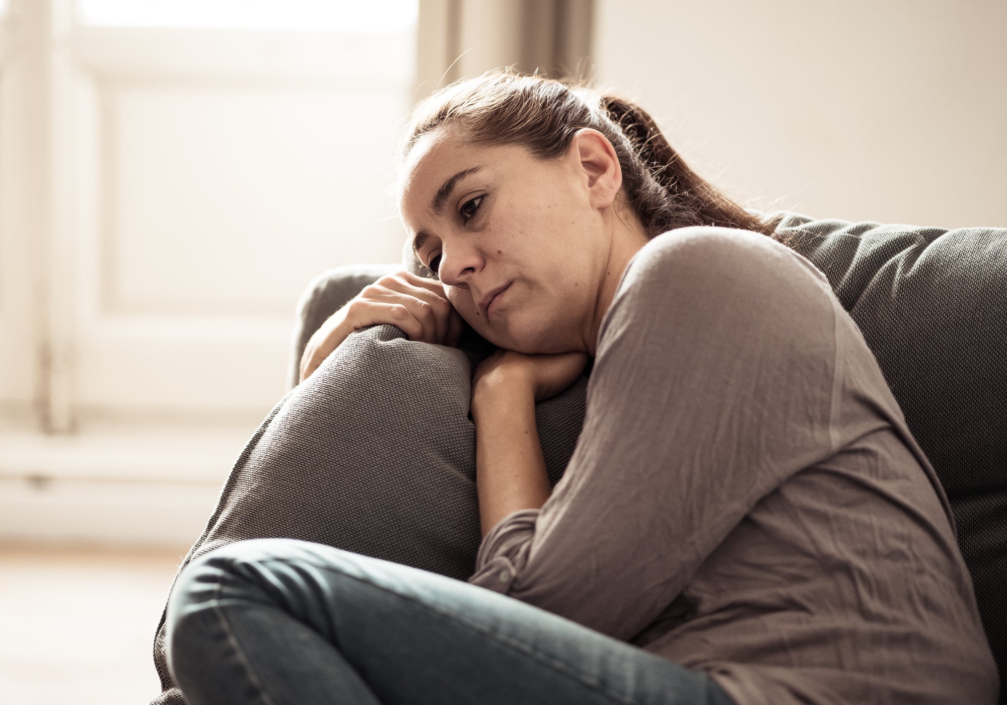 Person sitting on a sofa feeling unwell